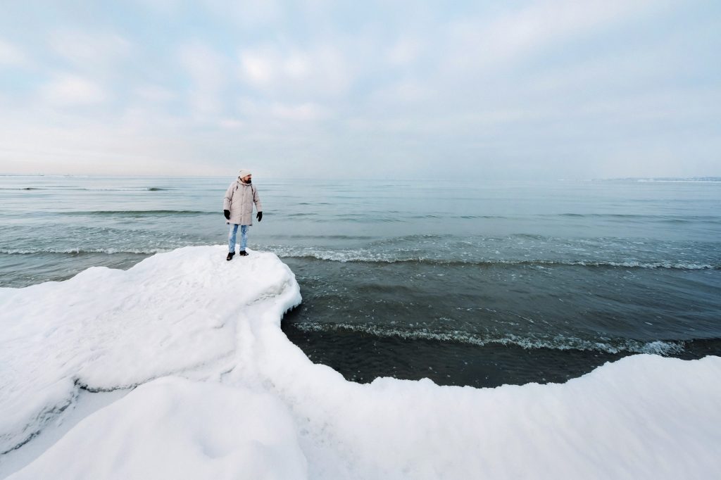 A tourist stands on the shore of the Baltic sea in winter. Winter near the Baltic States of Tallinn