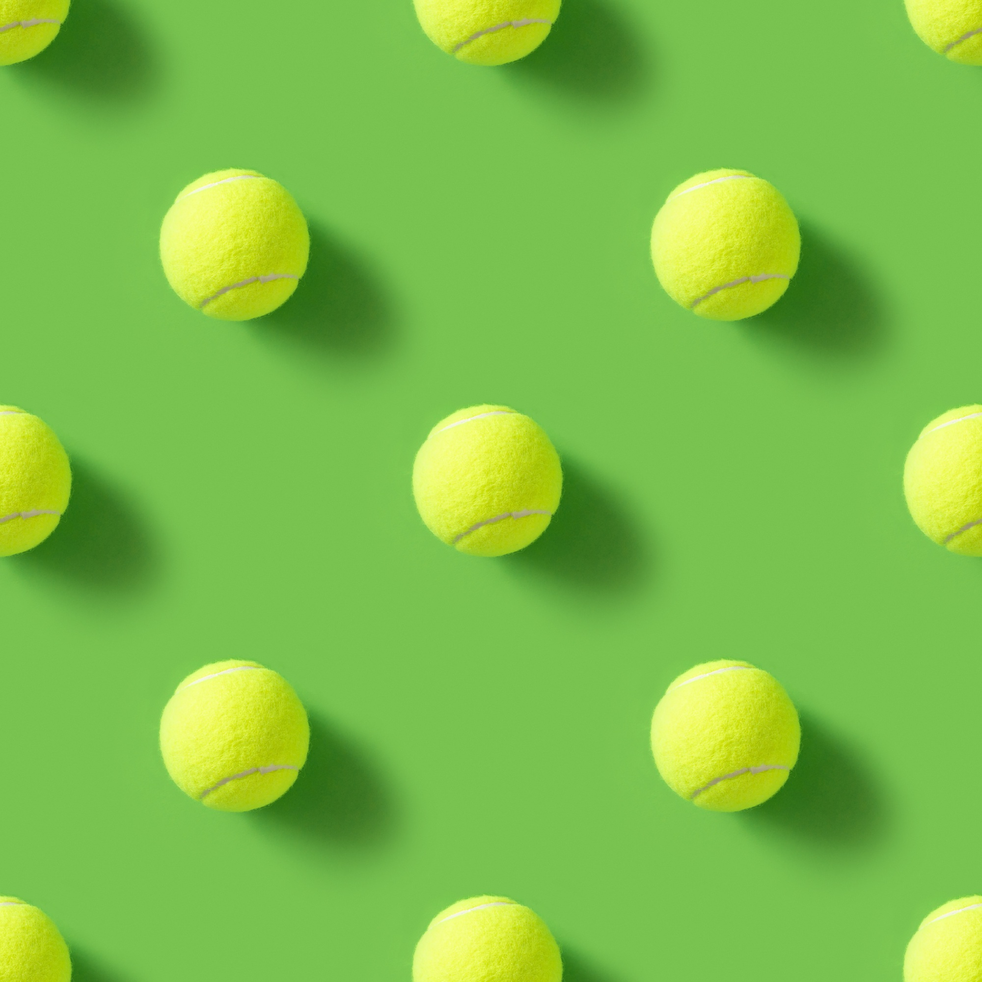 Seamless pattern of yellow tennis balls on green background. Summer sports.