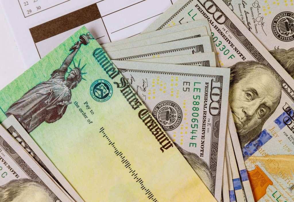 US Treasury check with hundred dollar bills representing unclaimed money California residents can claim from the state